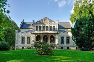 an old mansion with a green lawn at Haus Schlossgarten in Hinte