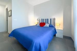 a blue bed with a red pillow on top of it at Beach Apartment with Pool, Terrace in Taramay +25 photos