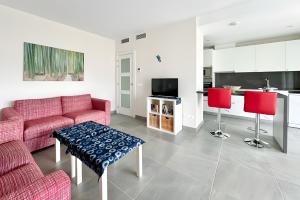 a living room with a red couch and red chairs at Beach Apartment with Pool, Terrace in Taramay