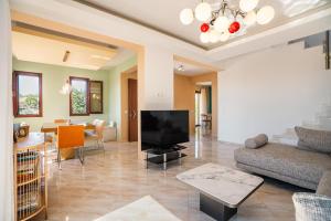a living room with a couch and a television at Sky Hills in Rhodes Town