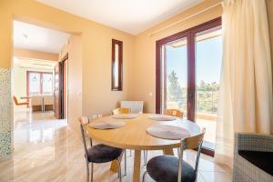 a dining room with a table and chairs and a large window at Sky Hills in Rhodes Town