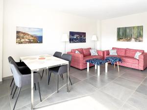 a living room with a couch and a table and chairs at Beach Apartment with Pool, Terrace in Taramay