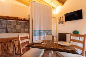 a dining room with a table with two glasses and chairs at Stazzo Jana in Trinità d'Agultu e Vignola