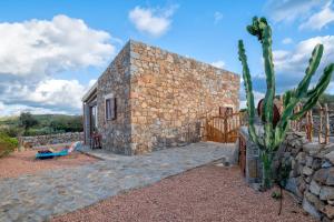a stone building with a cactus in front of it at Stazzo Jana in Trinità d'Agultu e Vignola