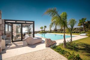a villa with a swimming pool and palm trees at Sky Hills in Rhodes Town