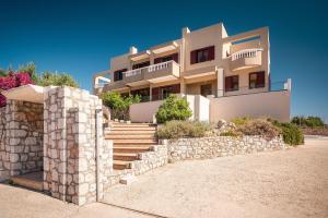 a large white house with a stone wall at Sky Hills in Rhodes Town