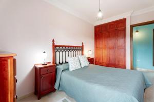 a bedroom with a blue bed and a wooden cabinet at Casa Girdana in Valverde