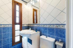 a blue tiled bathroom with a sink and a toilet at Casa Girdana in Valverde +19 photos