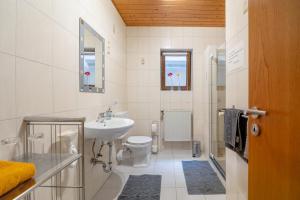 a white bathroom with a sink and a toilet at Casa Mia 2 in Bad Dürkheim