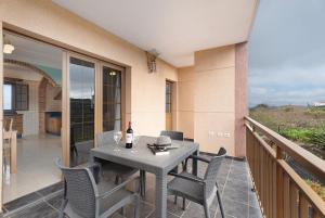 a table with chairs and a bottle of wine on a balcony at Casa Girdana in Valverde