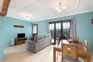a living room with blue walls and a table and a chair at Casa Girdana in Valverde