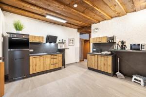a large kitchen with black appliances and wooden cabinets at Ferienwohnung Marktblick in Pottenstein +29 photos