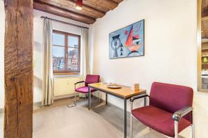 a room with a table and two chairs and a window at Ferienwohnung Marktblick in Pottenstein