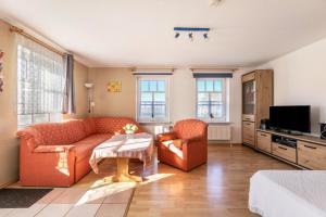 a living room with two couches and a tv at Hus Tingeltut Gerd Clausen in Pellworm