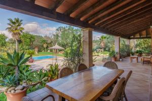 an outdoor patio with a wooden table and chairs at Son Barbudet in Campos