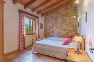 a bedroom with a bed and a stone wall at Son Barbudet in Campos +17 photos