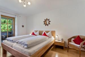 a bedroom with a large bed with red pillows at Ferienwohnung Edelweiß in Bad Reichenhall