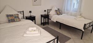 a room with two beds and two tables with towels at Mb Homes Hechingen in Hechingen
