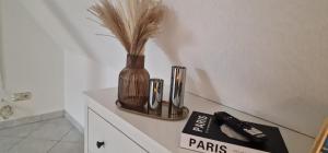 a vase with feathers in it sitting on a counter at Mb Homes Hechingen in Hechingen