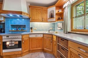 a kitchen with wooden cabinets and blue tiles at Ferienwohnung Edelweiß in Bad Reichenhall