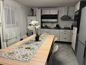 a kitchen with a wooden table with flowers on it at Mb Homes Hechingen in Hechingen +23 photos