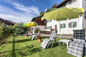 a group of chairs and an umbrella in a yard at Ferienwohnung Edelweiß in Bad Reichenhall