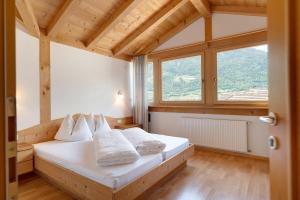 a bedroom with a bed with white pillows and a window at Hofanger in Lagundo