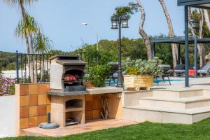 a patio with a pizza oven in a yard at Luxurious villa Sol de Mallorca in Sol de Mallorca