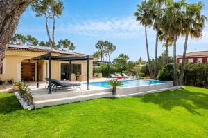 a backyard with a swimming pool and a house at Luxurious villa Sol de Mallorca in Sol de Mallorca