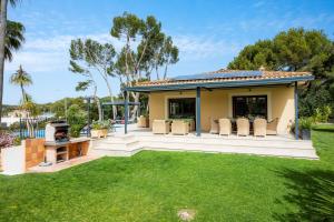 a house with a backyard with a grill and grass at Luxurious villa Sol de Mallorca in Sol de Mallorca