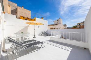 a balcony with a table and chairs and an umbrella at Ca Na Bel in Cala Ratjada