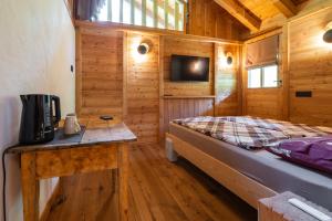 a bedroom in a log cabin with a bed and a desk at Maroc Mountain Chalet in Madonna di Campiglio