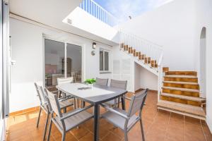 a dining room with a table and chairs and a staircase at Ca Na Bel in Cala Ratjada