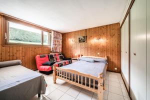 a small room with two beds and a chair at Appartement en residence in Morzine