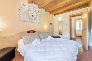 a bedroom with a large white bed with towels on it at Residence Tatiana B3 in Tremosine Sul Garda +25 photos