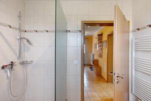a bathroom with a shower and a glass door at Großes Ferienhaus mit Seeblick in Leezen +20 photos