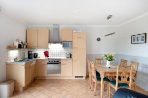 a kitchen and dining room with a table and chairs at Großes Ferienhaus mit Seeblick in Leezen