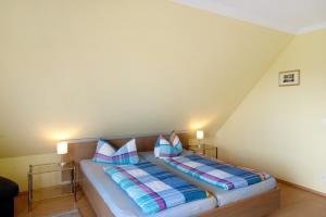 a bed in a room with two pillows on it at Großes Ferienhaus mit Seeblick in Leezen