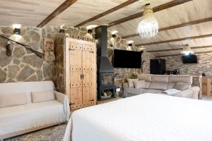 a bedroom with a bed and a stone wall at Loft Abanderao Piscina y Jacuzzi in Conil de la Frontera +17 photos