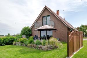 a house with an umbrella in the yard at Großes Ferienhaus mit Seeblick in Leezen