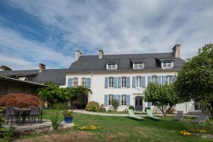a large white house with a table and chairs at Chambres D'hôtes Maison Galouÿe in Montgaillard