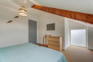a bedroom with a bed and a dresser and a window at Le Banc des Hermelles in Saint-Benoît-des-Ondes