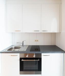 a kitchen with white cabinets and a sink at Fewo Schneckenhalde App 18 in Bad Säckingen