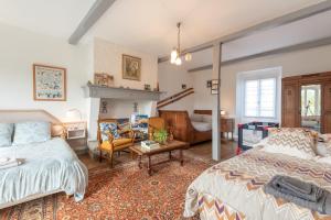 a bedroom with two beds and a living room at Chambres D'hôtes Maison Galouÿe in Montgaillard