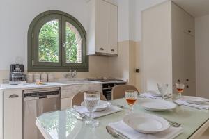 a kitchen with a table with plates and glasses on it at Mrs Kalis cottage in Andros +14 photos