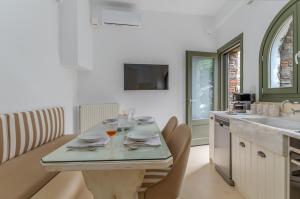 a kitchen with a table with chairs and a sink at Mrs Kalis cottage in Andros