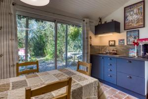 a kitchen with a table and a large window at Le Mazet Du Maréchal Ferrant in Maguelonne-la-Sauvage