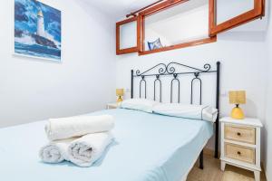 a bedroom with a bed with white sheets and a mirror at Los Arcos in Alcossebre +15 photos