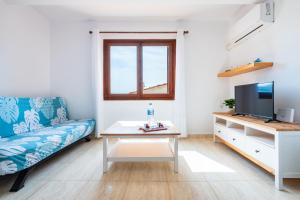 a living room with a couch and a tv and a table at Los Arcos in Alcossebre