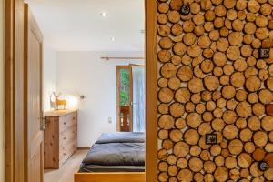 a bedroom with a wall made out of logs at Ferienwohnung Kraus Eibsee in Grainau